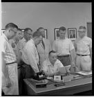 Men surrounding the desk of W.M. [Booger] Scales
